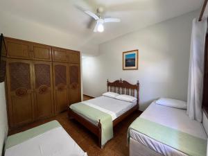ein Schlafzimmer mit zwei Betten und einem Deckenventilator in der Unterkunft Vila Mar Suítes in Bertioga