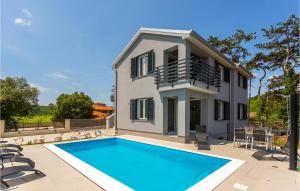 a villa with a swimming pool in front of a house at Awesome Apartment In Vrbnik With Wifi in Vrbnik +29 photos