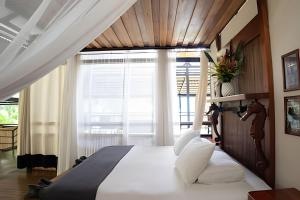 a bedroom with a large bed with a large window at Tumbo Resort in Cabo Matapalo