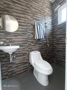 a bathroom with a white toilet and a sink at House for Rent DailyMonthly in General Santos