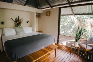 a bedroom with a bed and a large window at Tumbo de las Olas in Cabo Matapalo