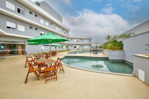 圣若昂-巴蒂斯塔-杜格罗里亚Comfort Hotel Serra da Canastra的带桌椅的露台和游泳池