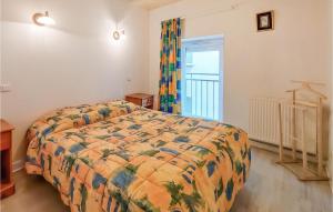 a bedroom with a bed with a colorful comforter at Amazing Apartment In Usson-En-Forez With Kitchen in Usson-en-Forez