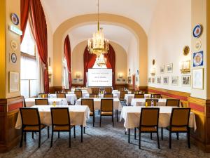 a conference room with tables and chairs and a projection screen at Hotel Regina in Vienna