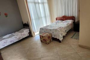 a bedroom with two twin beds and a table at Casa Aconchegante in Anchieta +14 photos