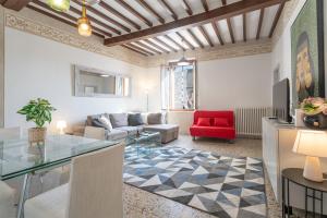 a living room with a glass table and a red chair at Urban Center Arezzo in Arezzo