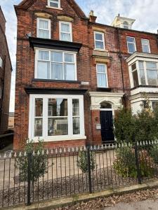 a brick house with white windows and a fence at Sunset Hideaway, Bridlington in Bridlington