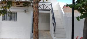 ein weißes Haus mit einem Baum im Eingangsbereich in der Unterkunft Postal del Golfo in Las Grutas + 14 Fotos