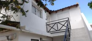 ein weißes Gebäude mit einem Balkon an der Seite in der Unterkunft Postal del Golfo in Las Grutas