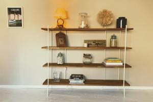 a shelf with books and other items on it at Charmante maison de ville 2 chambres avec terrasse, très calme in Marseillan