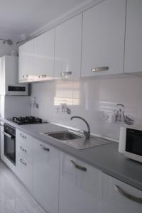 Una cocina blanca con fregadero y estufa. en Central Comfort, en Cluj-Napoca 10 fotos más