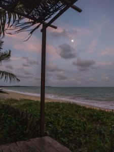 an umbrella on a beach with the ocean at Flat Ilha da Crôa in Barra de Santo Antônio