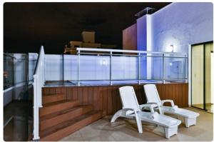 two white chairs sitting on top of a balcony at MG Apto com cozinha in Cuiabá