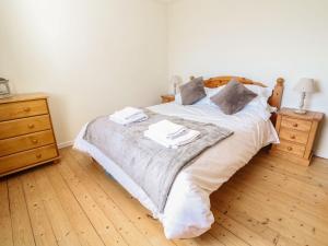 a bedroom with a large bed with two nightstands and a bed sidx sidx at Bryn Uchaf in Benllech