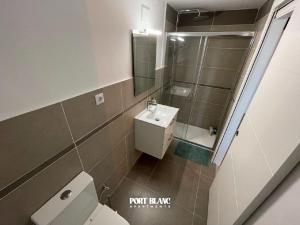 a bathroom with a toilet and a sink and a mirror at PortBlanc Apartments - 4 in Arenys de Mar +21 photos