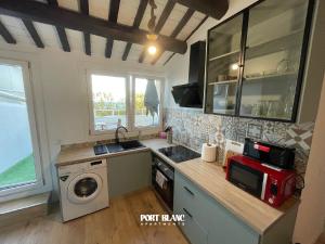 a kitchen with a sink and a washing machine at PortBlanc Apartments - 4 in Arenys de Mar