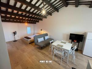 a living room with a couch and a table and a bed at PortBlanc Apartments - 4 in Arenys de Mar
