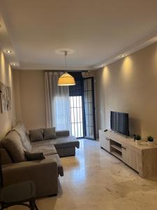 a living room with a couch and a flat screen tv at Piso céntrico en zona monumental de Antequera in Antequera