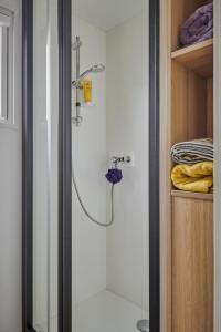 a shower in a bathroom with a glass door at Camping Club l'Air Marin in Vias