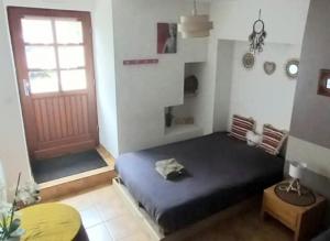 une chambre avec un lit et une porte rouge dans l'établissement Maison d hote " chez marie " sur Paimpont, à Paimpont