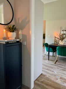 a dining room with a black cabinet and a table at APARTMENT KLAGENFURT Villa Frank No2 - with Free Parking, Smart-TV & Self Check-in in Klagenfurt