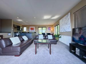 a living room with a leather couch and a coffee table at Apartment On Star Unit 1 in Sandy Bay