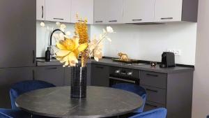 a kitchen with a table with a vase with yellow flowers at Aze - Forest Whisper in Bucharest