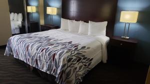 艾伦港Red Roof Inn Port Allen的一张大床,位于酒店带两盏灯的房间