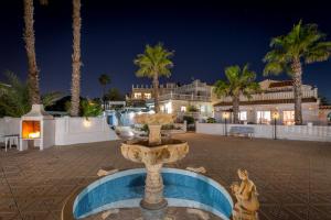 una fontana nel mezzo di un cortile con palme di Fidalsa Prime Mediterranean Beachfront a Orihuela Costa