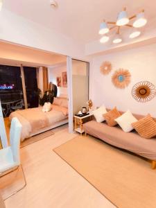 Una sala de estar con dos camas y un sofá en Azure Staycation by Oveecation Suites, en Manila
