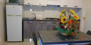 a kitchen with a table with a vase of flowers on it at Residence Jolly in Peschici +19 photos