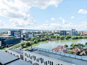 a view of a river in a city with buildings at Lakeside Apartment By Iulius Mall in Cluj-Napoca