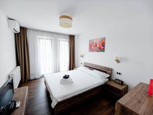 a bedroom with a bed and a flat screen tv at Lakeside Apartment By Iulius Mall in Cluj-Napoca