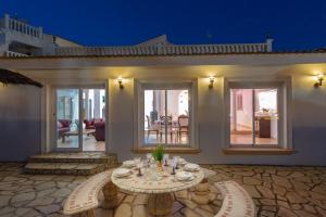 un patio con tavolo e sedie di fronte a una casa di Fidalsa Prime Mediterranean Beachfront a Orihuela Costa