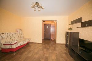 a living room with a couch and a television at Apartment On Kievskaya 90 in Tomsk