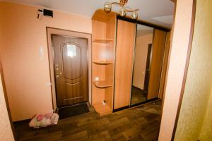 a hallway with a wooden door and a mirror at Apartment On Kievskaya 90 in Tomsk