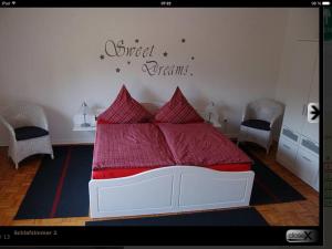 a bedroom with a bed with a red comforter at Dat Ferienhus in Bad Zwischenahn