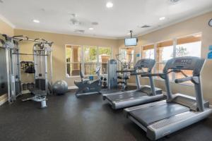 a gym with treadmills and machines in a room at Lakeside Escape in Orlando