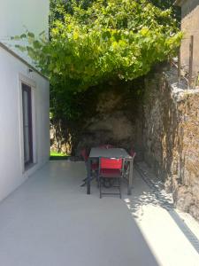 a table and chairs sitting under a wall at Bloom Cottage I - Sintra montain in Sintra