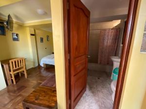 a room with a bathroom with a bed and a toilet at La Casa de Zarela in Huaraz +171 photos