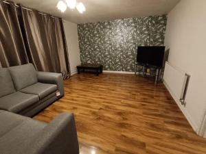 a living room with a couch and a flat screen tv at Sheffield Serenity in Heeley