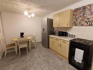 a kitchen with a table and a black refrigerator at Sheffield Serenity in Heeley