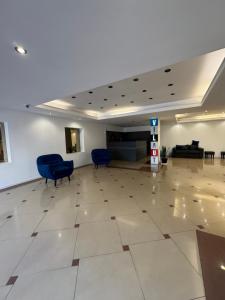 eine leere Lobby mit blauen Stühlen und einem Wartezimmer in der Unterkunft Departamento amoblado con Amenities 104 INVERHOME INMOBILIARIA in Cordoba + 9 Fotos