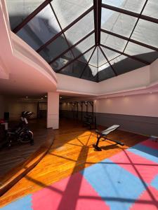 ein großer Raum mit Oberlicht und ein Fitnessstudio in der Unterkunft Departamento amoblado con Amenities 104 INVERHOME INMOBILIARIA in Cordoba