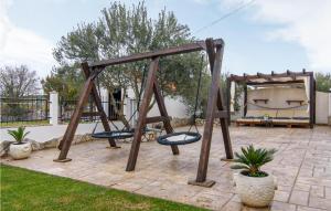 a playground with a swing in a yard at Amazing Home In Unesic With Wifi in Unešić +47 photos