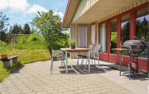 a patio with a table and chairs and a grill at Holiday Home Nørre Nebel 42 in Lønne Hede