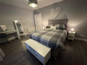 a bedroom with a bed and a desk and a heart wall at Bounty Town House Cumbria in Whitehaven