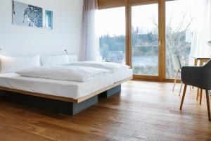1 dormitorio con cama y ventana grande en OX Hotel Altes Spital, en Müllheim