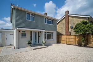 a house with a garage and a fence at Meadow Drive in Bembridge