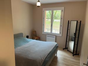 una camera da letto con un letto e una finestra di La maison dans les bois a Crayssac